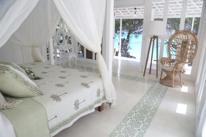 A bedroom with a peacock chair and sea view